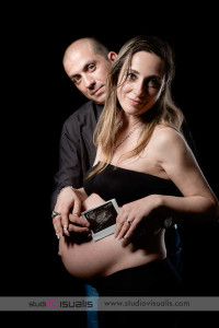 Donna incinta al nono mese con suo marito guardano in camera Ritratto in studio di futuri genitori con ecografia del feto