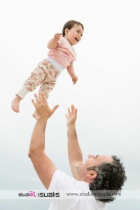 padre lancia in aria bambina sorridente sfondo cielo