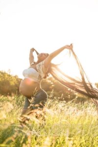 Ragazza incinta col velo al vento al parco