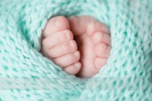 piedini di neonata su sfondo verde acqua