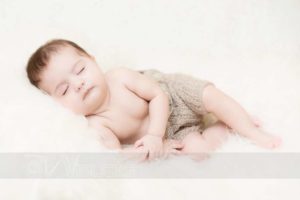 bambina addormentata su pellicciotto bianco