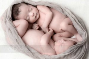 Gemelli neonati addormentati avvolti in tessuto come in utero materno