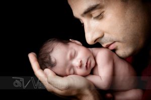 Primo piano di papá con neonata addormentata sulla mano