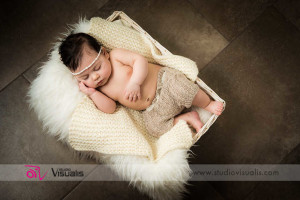 bambina addormentata dentro cestino bianco con pantaloncini di lana