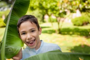 Bambino sorridente tra vegetazione