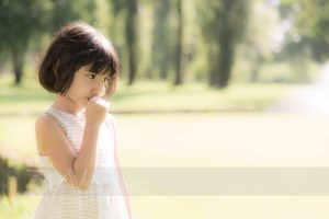 Ritratto di bambina pensierosa con dito in bocca