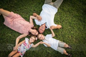 Famiglia distesa sul prato verde dall'alto