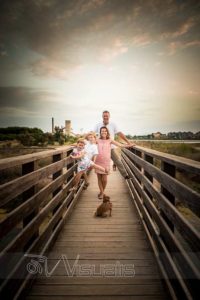 Famiglia con cani su un ponte al tramonto