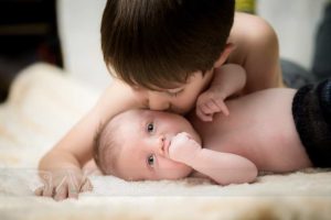 neonato sveglio baciato dal fratellino